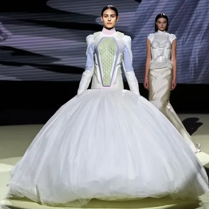 Model in layered modular skirt and corseted top on runway