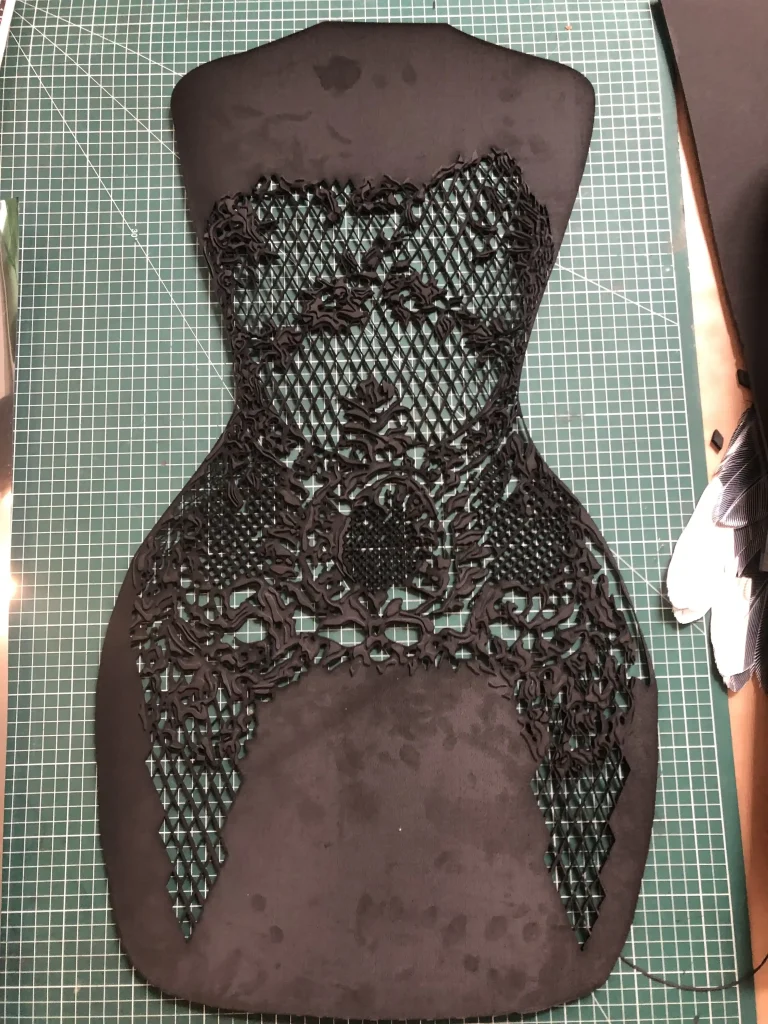 ntricate black mesh and lace pattern on rubber mold form